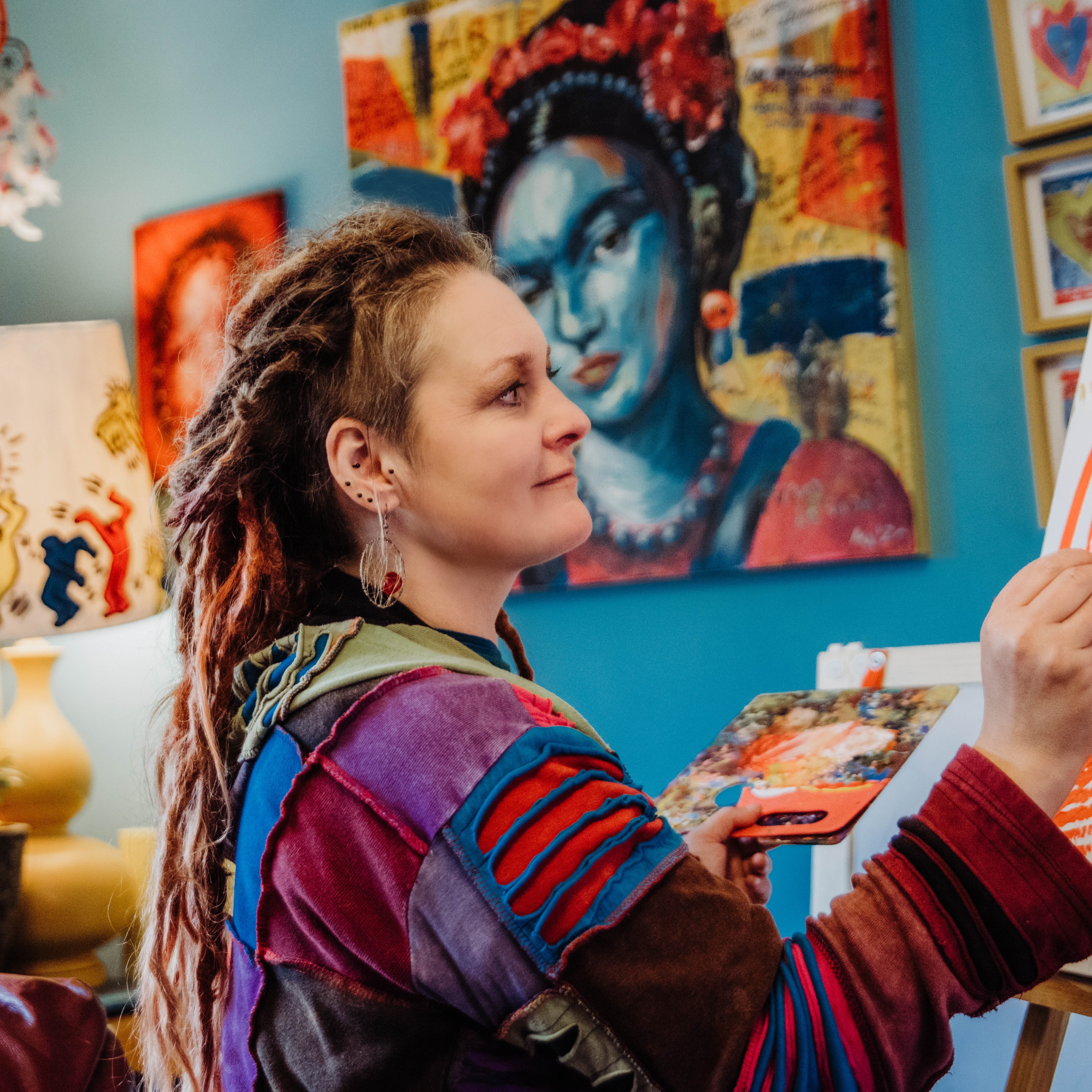 A photograph of Anna Wiercioch as she is painting and looking away from the camera